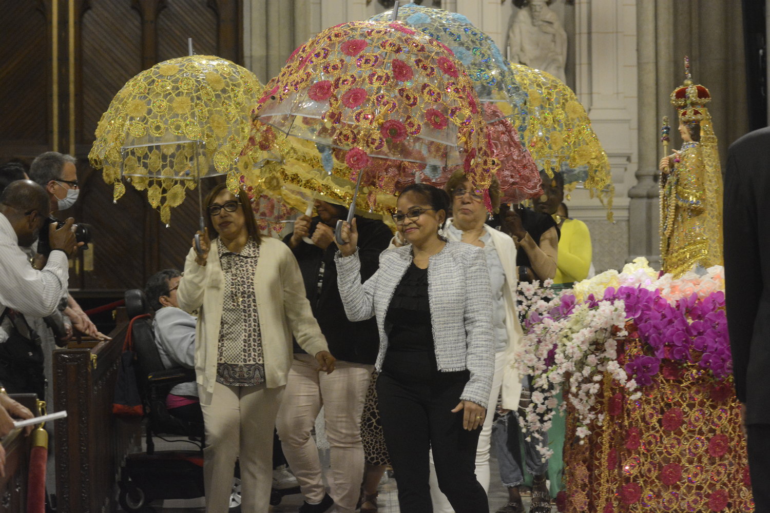 Ornate umbrellas were held aloft in honor of Our Lady of Good Health, right, at St. Patrick’s Cathedral.